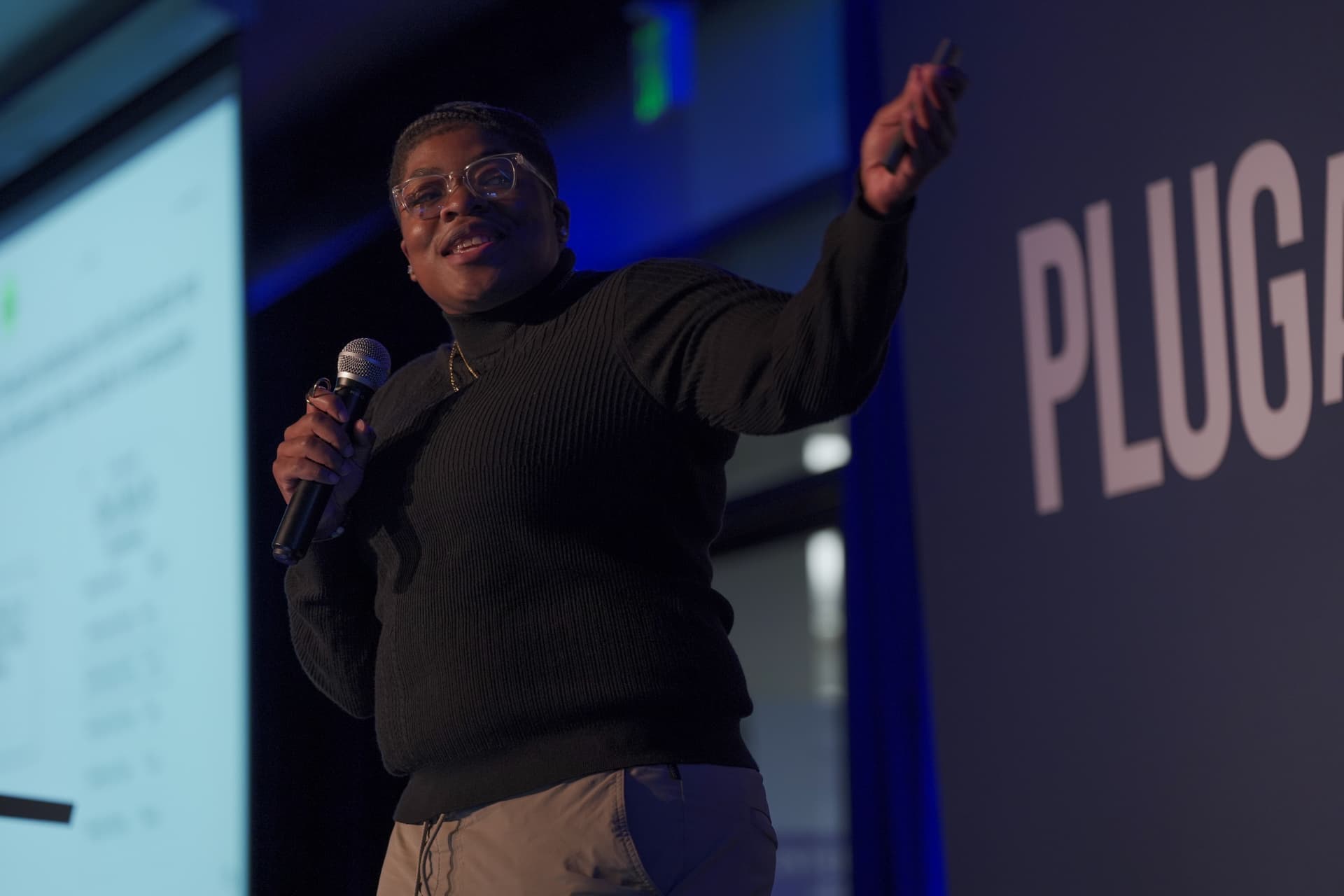 Jannae Gammage speaking on stage and gesturing to the audience